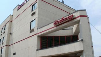 The image shows a building named Galaxy Motel with a beige facade and red accents, including a large sign reading 